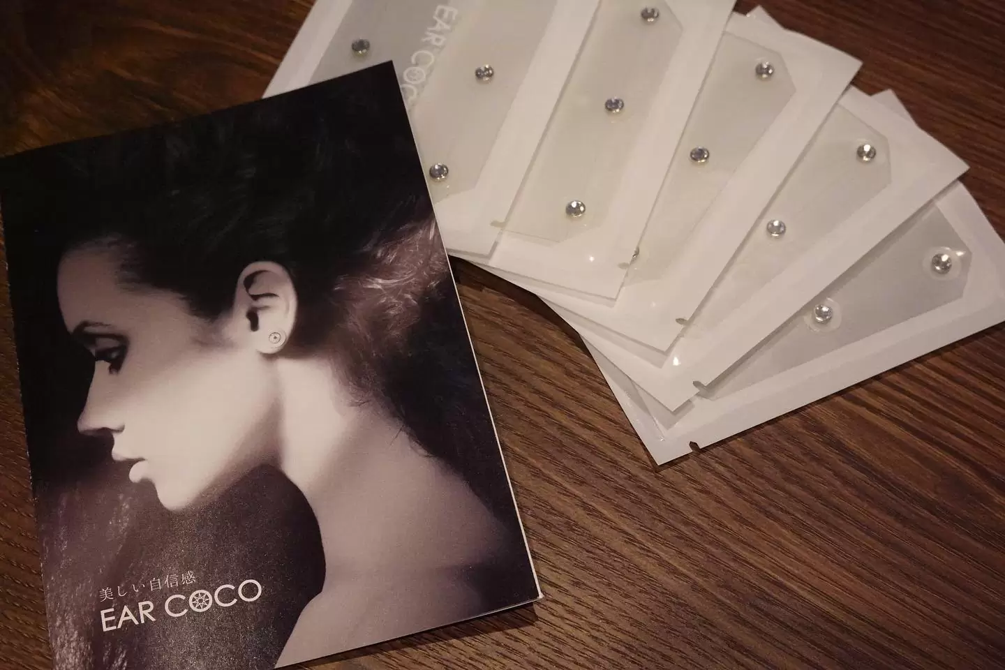 .ビューティワールドの体験ブースでも即効性に驚きの声が飛び交った...【EAR COCO】イヤーココシグネチャー¥8800(6パッチ×5シート).手間をかけずに綺麗になりたい“ながら美容”派に吉報！耳に貼るだけでたるみを改善、ジェエリー感覚の磁気ピアスがラインナップ。永久磁石の中でも最強な磁力を持つネオジムと、物理的な刺激を与える極小ピンV-PINによるツボ刺激の合わせ技「2重磁極方式」により血液循環を促進。血流の改善効果で顔のむくみを解消し、フェイスラインもスッキリ整え、キュッと引き締まった小顔に見せてくれます。金属部分はニッケルフリーな純金メッキ加工、3M医療用テープ使用で長時間着用しても人体に無害な安心・安全な仕様。高品質のクリスタルが美しく輝いて、見た目はまるで一粒ダイヤピアス。カジュアルでもフォーマルでも場面を選ばず装いをアップグレードします。発売開始以来、入手困難な人気商品がATENAに数量限定で緊急入荷、特別に手に入れられるこのチャンスを逃さずにお試しください。#earcoco #イヤーココ #プレミアムクリスタル #二重磁極方式 #スピード美容 #earcoco熊本#熊本 #銀座通り #atenarelaxationsalon